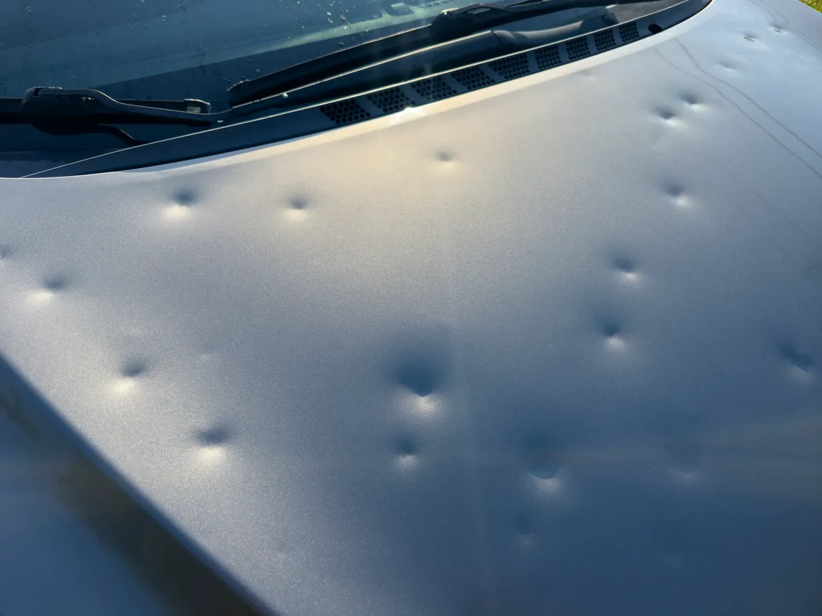 Hood covered in hail dents at intake